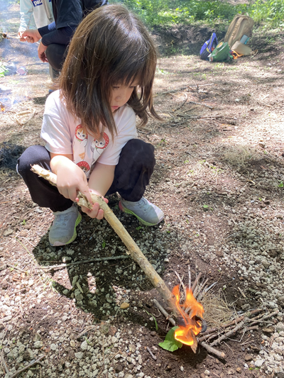A child adjusts a small flame carefully, practicing distance and control.